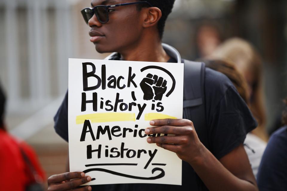 Sammie Fowler holds a sign at a Feb. 21 rally at the University of North Florida to urge protection of UNF's diversity efforts, which some view as under attack by Gov. Ron DeSantis' policies.