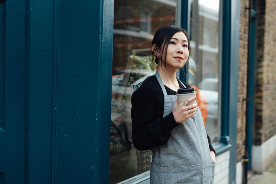 Young Asian woman taking a break while working at a local store in the neighbourhood. Small business. Community business. Pride in work portrait.