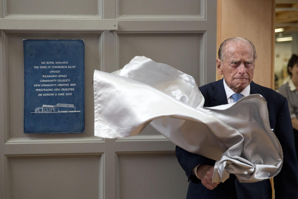 FILE - In this Monday June 8, 2015 file photo, Britain's Prince Philip, the husband of Queen Elizabeth II, unveils a plaque at the end of his visit to Richmond Adult Community College in Richmond, south west London. Buckingham Palace says Prince Philip, husband of Queen Elizabeth II, has died aged 99.(AP Photo/Matt Dunham, Pool, File)