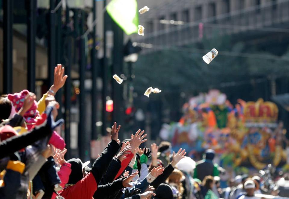 People reach for beads and trinkets during the Krewe of Rex parade on Mardi Gras in New Orleans, Tuesday, Feb. 17, 2015.