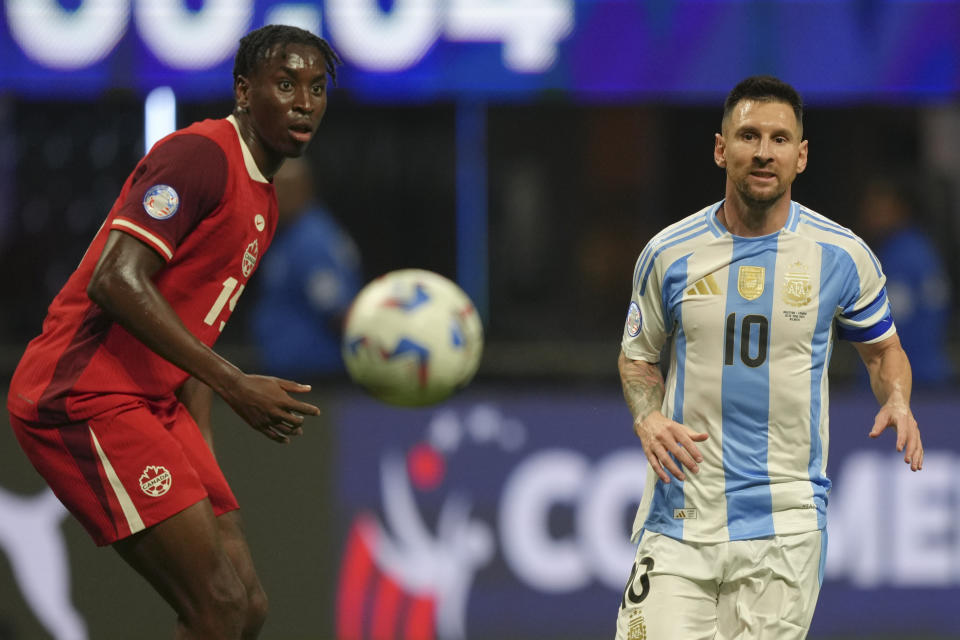 El delantero argentino Lionel Messi (derecha) y el zaguero canadiense Moïse Bombito observan el balón durante el partido del Grupo A de la Copa América, el jueves 20 de junio de 2024, en Atlanta. (AP Foto/Jason Allen)