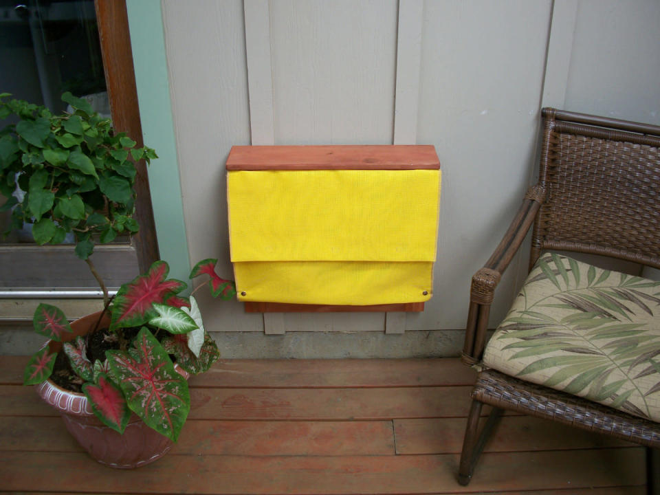 The yellow fabric conceals a <a href="http://etsy.me/WxB0A3" rel="nofollow noopener" target="_blank" data-ylk="slk:Murphy bed for pets by Kohala Creations;elm:context_link;itc:0;sec:content-canvas" class="link ">Murphy bed for pets by Kohala Creations</a>. Click to the next photo to see it open and occupied.