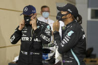 FILE - In this Saturday, Nov. 28, 2020 file photo Mercedes driver Lewis Hamilton of Britain, right, pole position, and Mercedes driver Valtteri Bottas of Finland, second position wear their masks after the qualifying session at the Formula One Bahrain International Circuit in Sakhir, Bahrain. World champion Lewis Hamilton tested positive for COVID-19 and will miss the Sakhir Grand Prix this weekend, his Mercedes-AMG Petronas F1 Team said Tuesday Dec. 1, 2020. (Hamad Mohammed, Pool via AP, File)