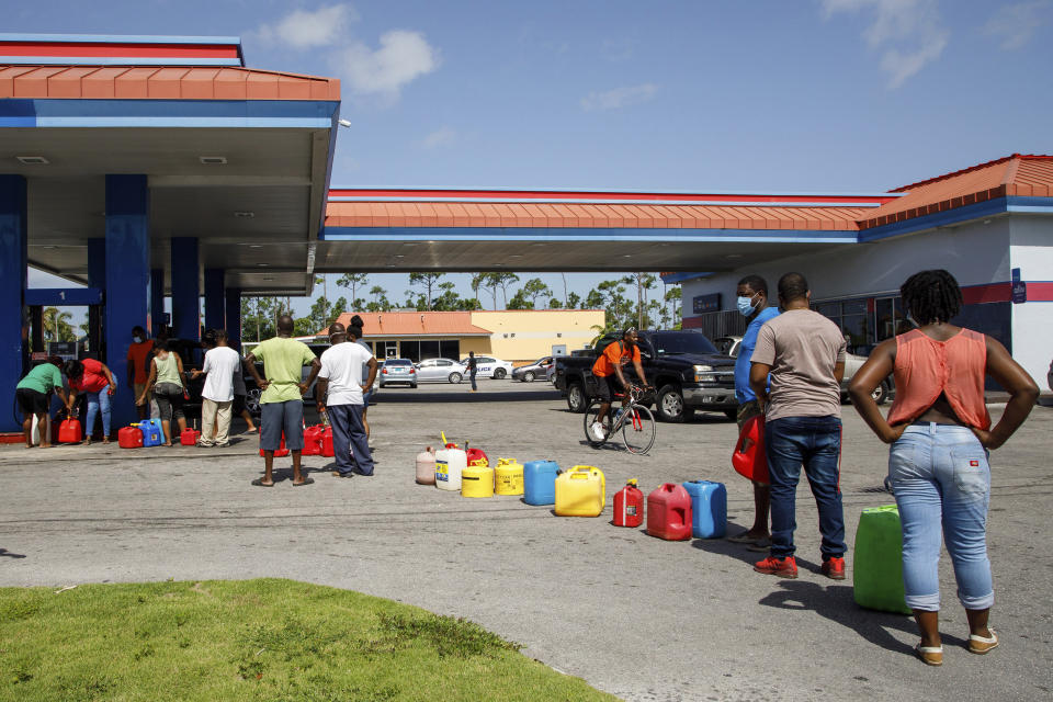 Residents wait in line to fill their containers with gasoline before the arrival of Hurricane Isaias in Freeport, Grand Bahama, Bahamas, Friday, July 31, 2020. (AP Photo/Tim Aylen)