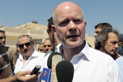 British Foreign Minister William Hague (C) speaks to the press as Jordan's Foreign Minister Nasser Joudeh (L) listens on during their visit to the Syrian refugee camp of Bashabsha, near the Jordanian city of Ramtha, at the Syrian border