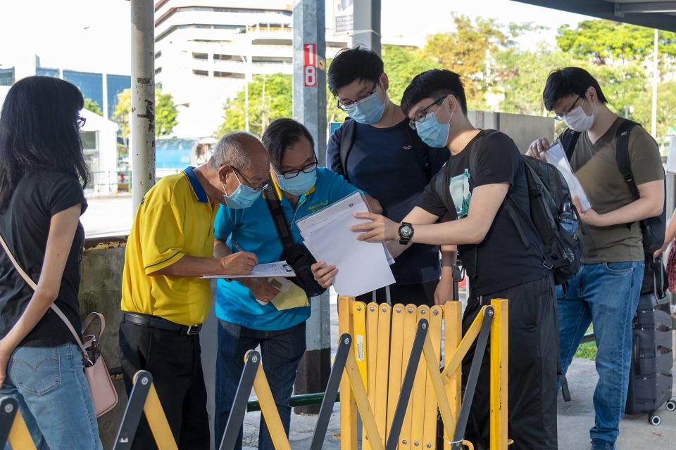 Travellers having their documents checked prior to boarding their bus to Malaysia at the Queen Street bus terminal on Monday (29 November). (PHOTO: Dhany Osman / Yahoo News Singapore)