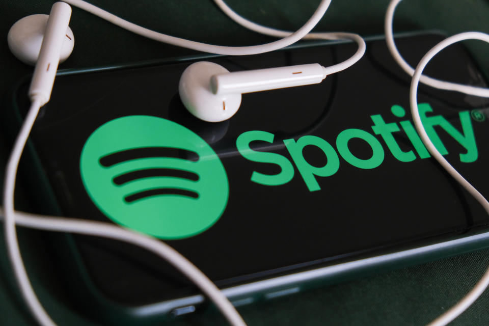 Spotify logo displayed on a phone screen and headphones are seen in this illustration photo taken in Krakow, Poland on February 3, 2022. (Photo Illustration by Jakub Porzycki/NurPhoto via Getty Images)