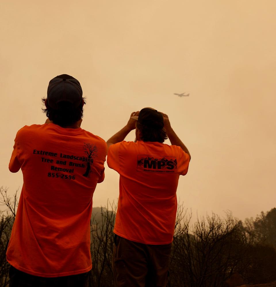 Matt Marvin, left, and Ray Slocum watch as a 747 aerial firefighting tanker prepares to drop retardant on a hot spot on the Creek Fire near Shaver Lake, California, on Sept. 9, 2020. The 747 is known as the Global Supertanker, and it is the world's largest aerial firefighting tanker.