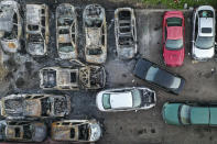 Burnt vehicles remain in a parking lot along East Lake Street after they were destroyed in a protest two days prior, Tuesday, June 2, 2020, in Minneapolis. Protests continued following the death of George Floyd, who died after being restrained by Minneapolis police officers on May 25. (AP Photo/John Minchillo)