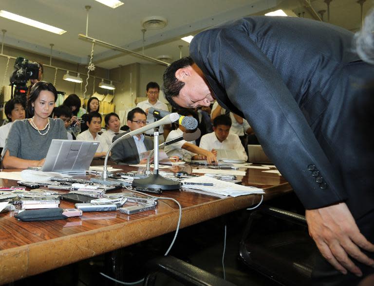 Yasuhiro Sato, president of Mizuho Financial Group, bows his head at a press conference in Tokyo on October 8, 2013 after Mizuho was told off by regulators for lending money to gangsters