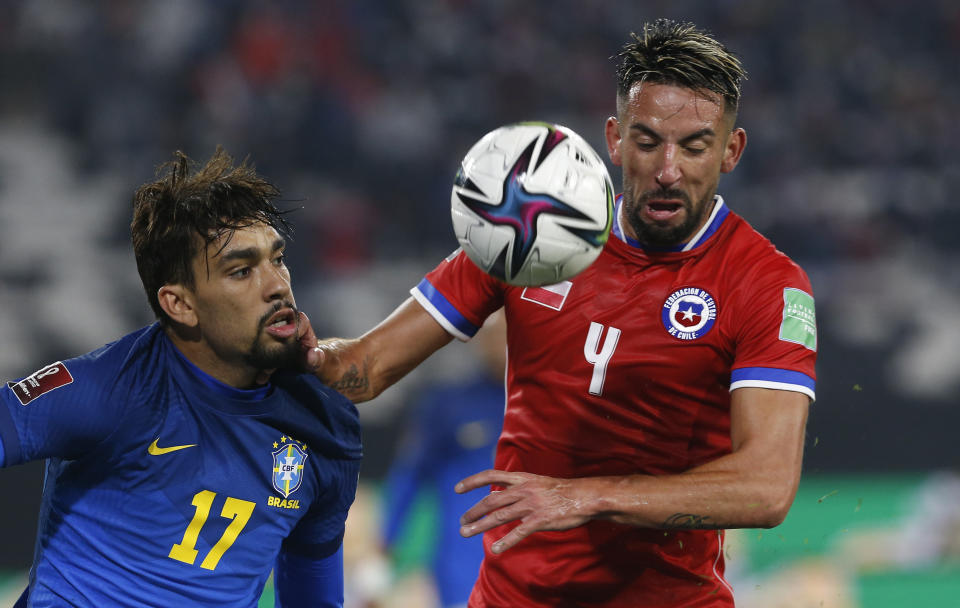 Brazil's Lucas Paqueta, left, and Chile's Mauricio Isla battle for the ball during a qualifying soccer match for the FIFA World Cup Qatar 2022 at Monumental Stadium in Santiago, Chile, Thursday, Sept. 2, 2021. (Claudio Reyes/Pool via AP)