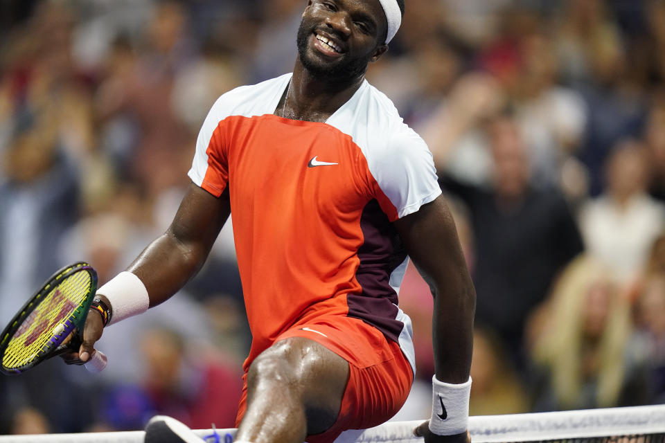 Frances Tiafoe, of the United States, climbs over the net after a volley with Carlos Alcaraz, of Spain, during the semifinals of the U.S. Open tennis championships, Friday, Sept. 9, 2022, in New York. (AP Photo/Charles Krupa)