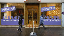 People walk past the Pirate Party election office in Reykjavik, Iceland, Wednesday, Sept. 22, 2021. Climate change is top of the agenda when voters in Iceland head to the polls for general elections on Saturday, following an exceptionally warm summer and an election campaign defined by a wide-reaching debate on global warming. The Pirate Party wants to support a plant-based diet among the population. (AP Photo/Brynjar Gunnarsson)