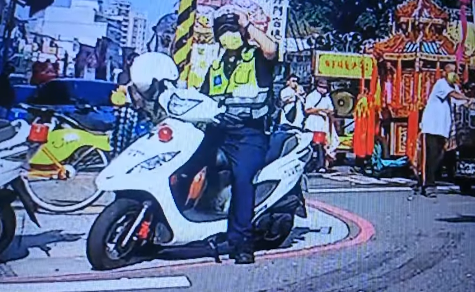 一名員警騎車前未發覺自己已經戴上安全帽，又拿請另一頂安全帽想戴上。（翻攝自臉書「爆怨公社」）