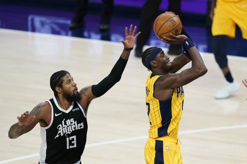 Indiana Pacers' Caris LeVert (22) shoots against Los Angeles Clippers' Paul George (13) during the second half of an NBA basketball game, Tuesday, April 13, 2021, in Indianapolis. (AP Photo/Darron Cummings)