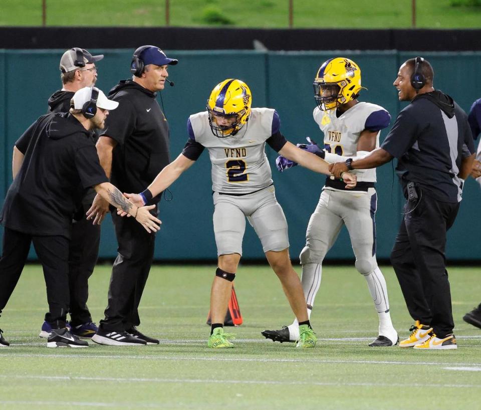 Lamar coaches congratulate quarterback Gannon Carey (2) after he scored the first points in the first half of a UIL high football game at Choctaw Stadium in Arlington, Texas, Thursday, Oct. 26, 2023. Lamar led Bowie 14-7 at the half. (Special to the Star-Telegram Bob Booth)