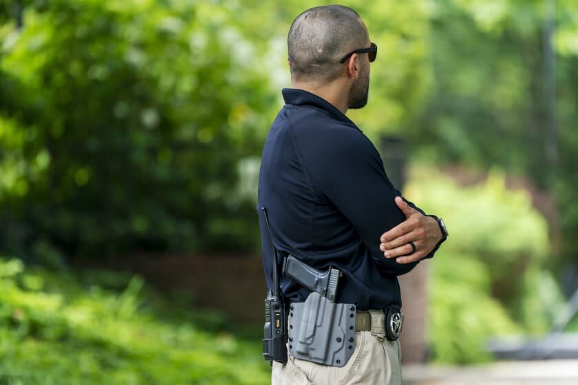 FILE - A U.S. Marshal patrols outside the home of Supreme Court Justice Brett Kavanaugh, in Chevy Chase, Md., June 8, 2022. The House has given final approval to legislation to allow around-the-clock security protection for families of Supreme Court justices. The vote on Tuesday came one week after a man carrying a gun, knife and zip ties was arrested near Justice Brett Kavanaugh's house after threatening to kill the justice. (AP Photo/Jacquelyn Martin, File)