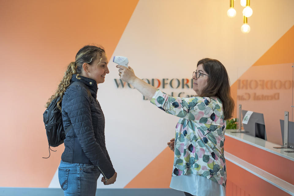 A member of staff has their temperature checked as they arrived to work at Woodford Dental Care in north London, as the practice opens up for the first time since the UK went into coronavirus lockdown.