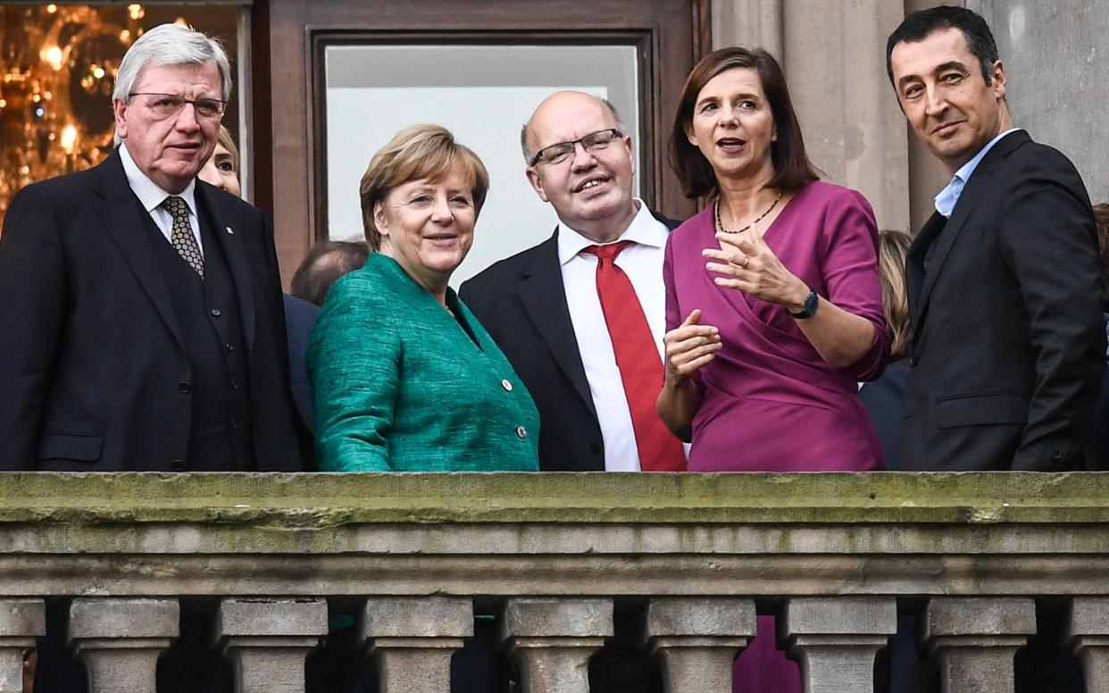 Mrs Merkel, Volker Bouffier, Minister President of Hesse, and The Federal Green Party Chairman, Cem Ozdemir are seen on a balcony of the 'Reichstag' building during first coalition talks - EPA