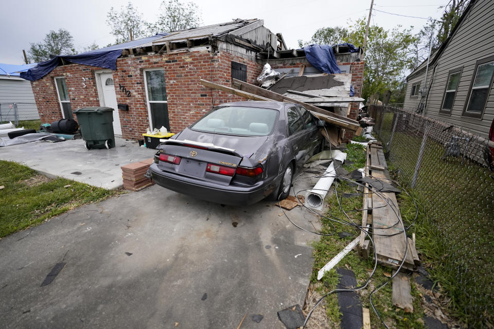 A heavily damaged home and car sit unrepaired in the aftermath of Hurricane Laura and Hurricane Delta, in Lake Charles, La., Friday, Dec. 4, 2020. (AP Photo/Gerald Herbert)