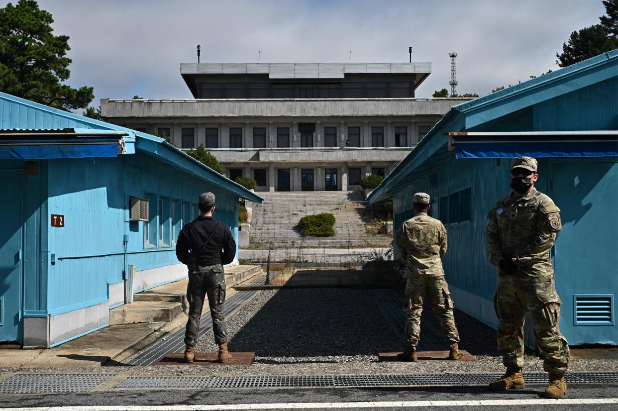 United Nations Command soldiers, right, and a South Korean soldier, left, stand guard before North Korea's Panmon Hall, the military demarcation line separating North and South Korea.