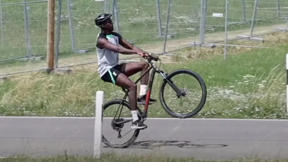  A man doing a wheelie on a bike 