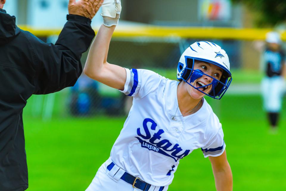 Paige Antcliff of LCC high-fives Head Coach Marc Kibby as she rounds 3rd base after hitting a solo homerun in the 3rd inning to put LCC up 3-1  during their NJCAA Great Lakes District B Softball Championship Game with Oakland Community College Saturday May 13, 2023 in Stevensville.