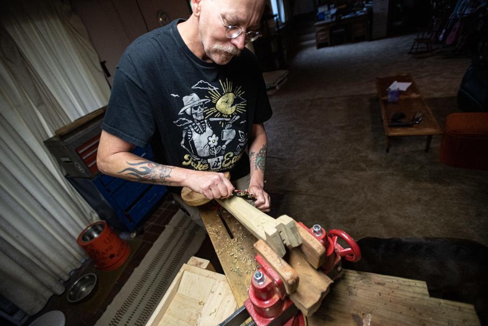 Wesley Hood, 48, of Okemos, forms a guitar neck by hand for one of his custom made Steel Belly Guitars.