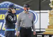 Martin Truex Jr. talks on a cell phone as team owner Joe Gibbs stands nearby after Truex won the NASCAR Cup Series auto race at Darlington Raceway, Sunday, May 9, 2021, in Darlington, S.C. (AP Photo/Terry Renna)