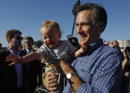 Republican presidential candidate and former Massachusetts Governor Mitt Romney returns a baby to his mother in the audience at a campaign rally at Eastern Shipbuilding Group in Panama City, Florida January 28, 2012. (Brian Snyder/Reuters)