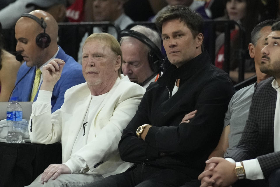 Mark Davis, left, owner of the Las Vegas Aces and Las Vegas Raiders, sits beside former football player Tom Brady during the first half in Game 1 of a WNBA basketball final playoff series between the Las Vegas Aces and the New York Liberty, Sunday, Oct. 8, 2023, in Las Vegas. (AP Photo/John Locher)