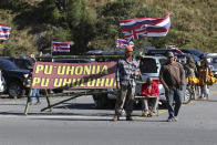 Native Hawaiian activists gather at the base of Hawaii's Mauna Kea, Sunday, July 14, 2019. Hundreds of demonstrators are gathered at the base of Hawaii's tallest mountain to protest the construction of a giant telescope on land that some Native Hawaiians consider sacred. State and local officials will try to close the road to the summit of Mauna Kea Monday morning to allow trucks carrying construction equipment to make their way to the top. Officials say anyone breaking the law will be prosecuted. Protestors have blocked the roadway during previous attempts to begin construction and have been arrested. (AP Photo/Caleb Jones)
