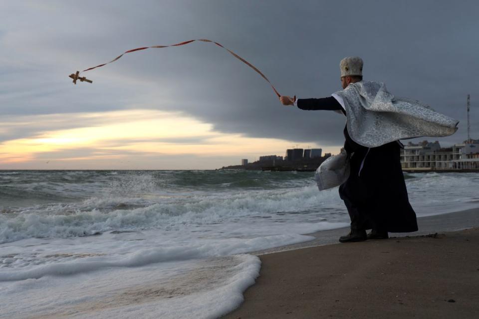 An Orthodox Church of Ukraine priest blesses the waters of the Black Sea amid Epiphany celebrations in Odesa, Ukraine, on Jan. 6, 2024. (Oleksandr Gimanov/AFP/Getty Images)