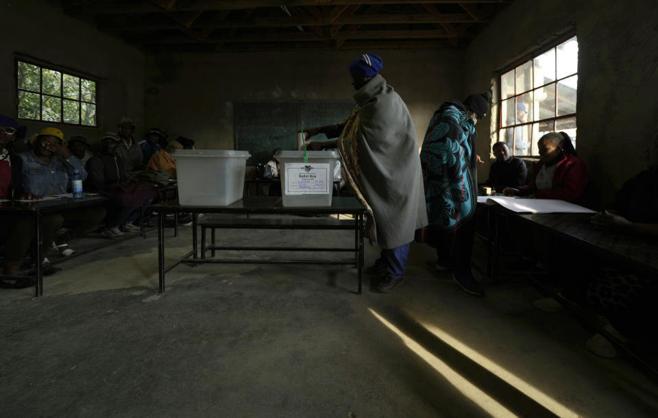 A man wearing a blanket casts his vote at a poling station in Maseru, Lesotho, Friday, Oct. 7, 2022. Voters across the picturesque mountain kingdom of Lesotho are heading to the polls Friday to elect a leader to find solutions to high unemployment and crime. (AP Photo/Themba Hadebe)