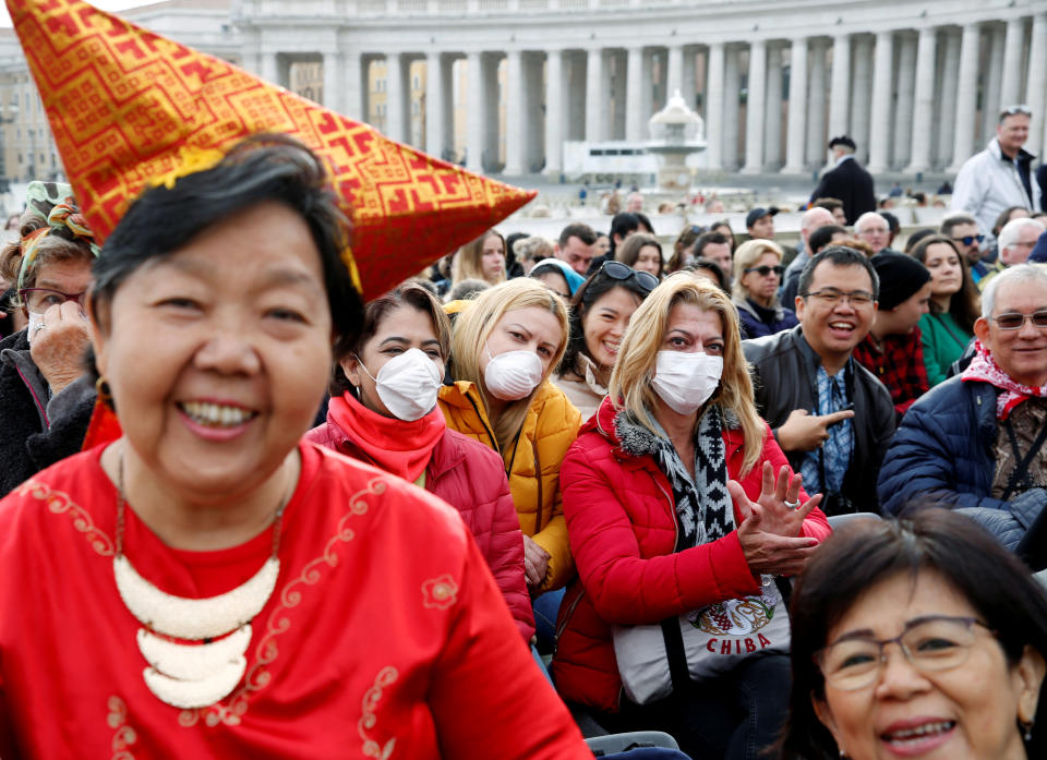 People, a few in face masks, wait for Pope Francis to arrive for his weekly general audience at the Vatican. (Photo: Remo Casilli / Reuters)