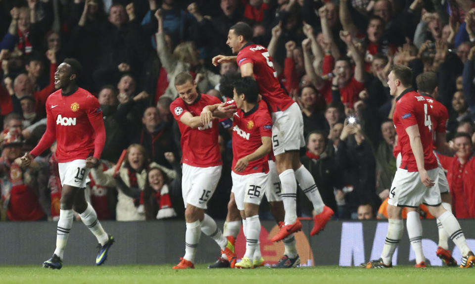 Manchester United's Nemanja Vidic, second left, celebrates with his teammates after scoring the opening goal during the Champions League quarterfinal first leg soccer match between Manchester United and Bayern Munich at Old Trafford Stadium, Manchester, England, Tuesday, April 1, 2014.(AP Photo/Jon Super)