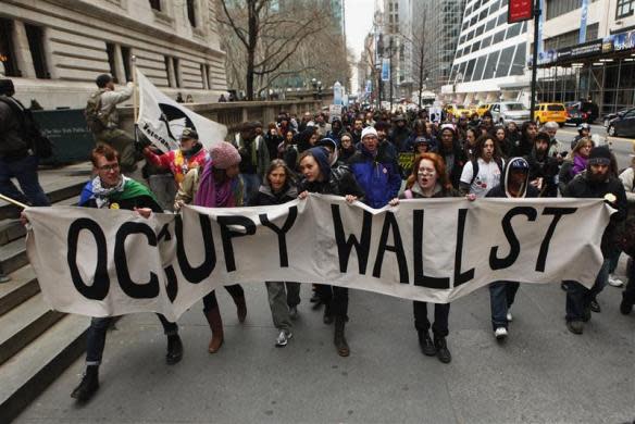 Members of the Occupy Wall St movement carry a sign during a "national day of action" demonstration by the movement in New York February 29, 2012.