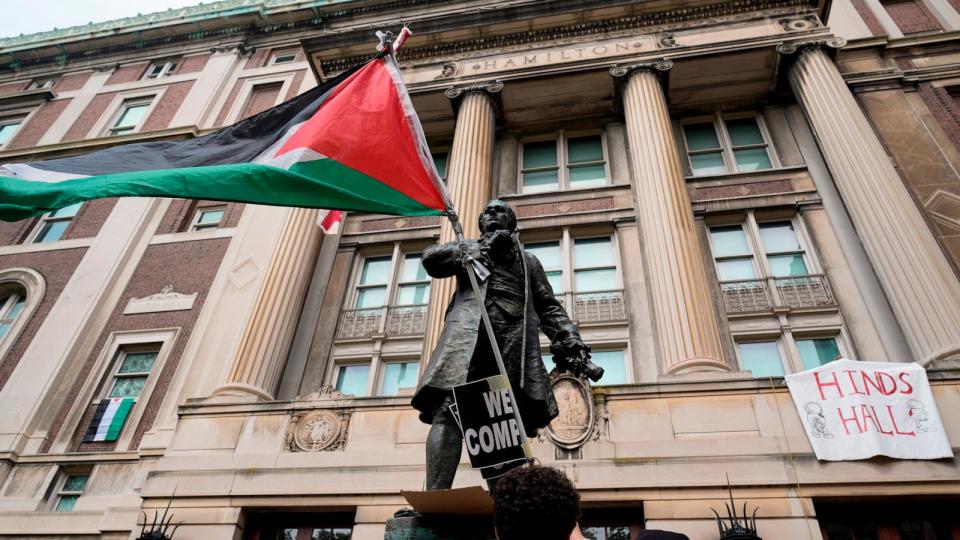 PHOTO: A student protester parades a Palestinian flag outside the entrance to Hamilton Hall on the campus of Columbia University, Tuesday, April 30, 2024, in New York. (Mary Altaffer/AP)