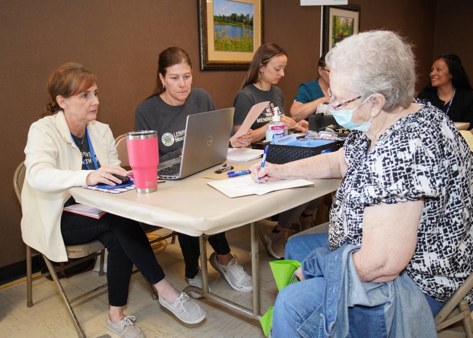 Kim Gunn, left, and Mari Reko from the Lenawee County Health Department discuss adult vaccinations with Clayton resident Shirley Snead during Thursday's Health Check clinic in Adrian.