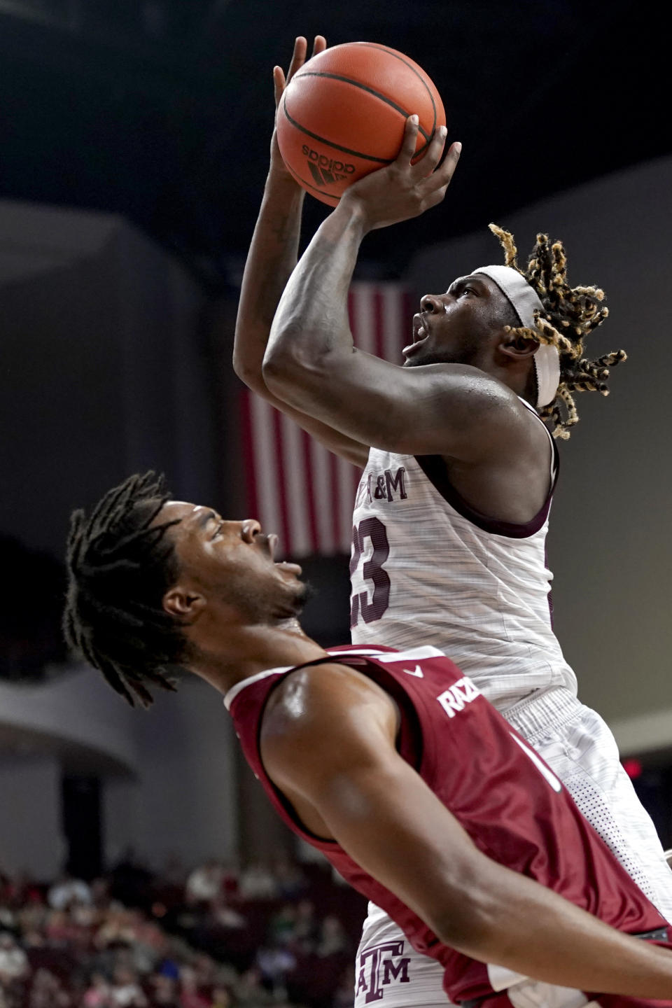 Texas A&M guard Tyrece Radford (23) drives to the basket as he is fouled by Arkansas guard Stanley Umude (0) during the second half of an NCAA college basketball game Saturday, Jan. 8, 2022, in College Station, Texas. (AP Photo/Sam Craft)