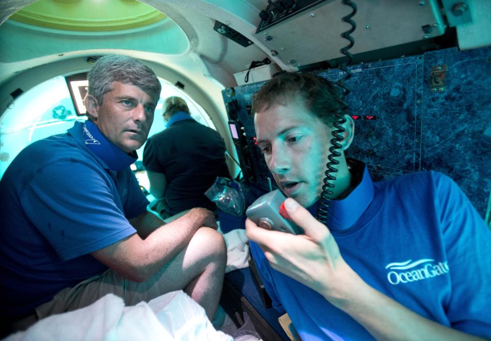 FILE - Submersible pilot Randy Holt, right, communicates with the support boat as he and Stockton Rush, left, CEO and Co-Founder of OceanGate, dive in the company's submersible, "Antipodes," about three miles off the coast of Fort Lauderdale, Fla., June 28, 2013. Rescuers are racing against time to find the missing submersible carrying five people, who were reported overdue Sunday night, June 18, 2023. (AP Photo/Wilfredo Lee, File)