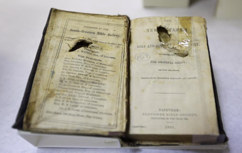 The bible belonging to Confederate soldier C. Robey, who was wounded on the third day of Gettysburg battle, is prepared for display in a work room at the museum of the Confederacy in Richmond, Va., Wednesday, May 1, 2013. The Museum of the Confederacy will open the exhibit “Gettysburg: They walked through blood” on May 11 to commemorate the 150th anniversary of the Battle of Gettysburg. (AP Photo/Steve Helber)