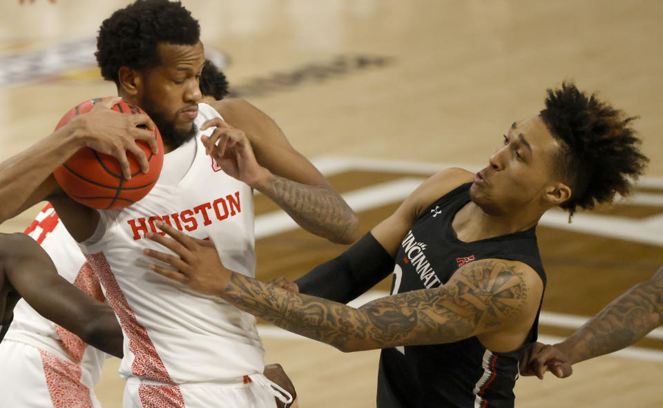 Houston forward Justin Gorham (4) and Cincinnati guard Jeremiah Davenport (24) fight for a rebound during the second half of an NCAA college basketball game in the final round of the American Athletic Conference men's tournament Sunday, March 14, 2021, in Fort Worth, Texas. (AP Photo/Ron Jenkins)