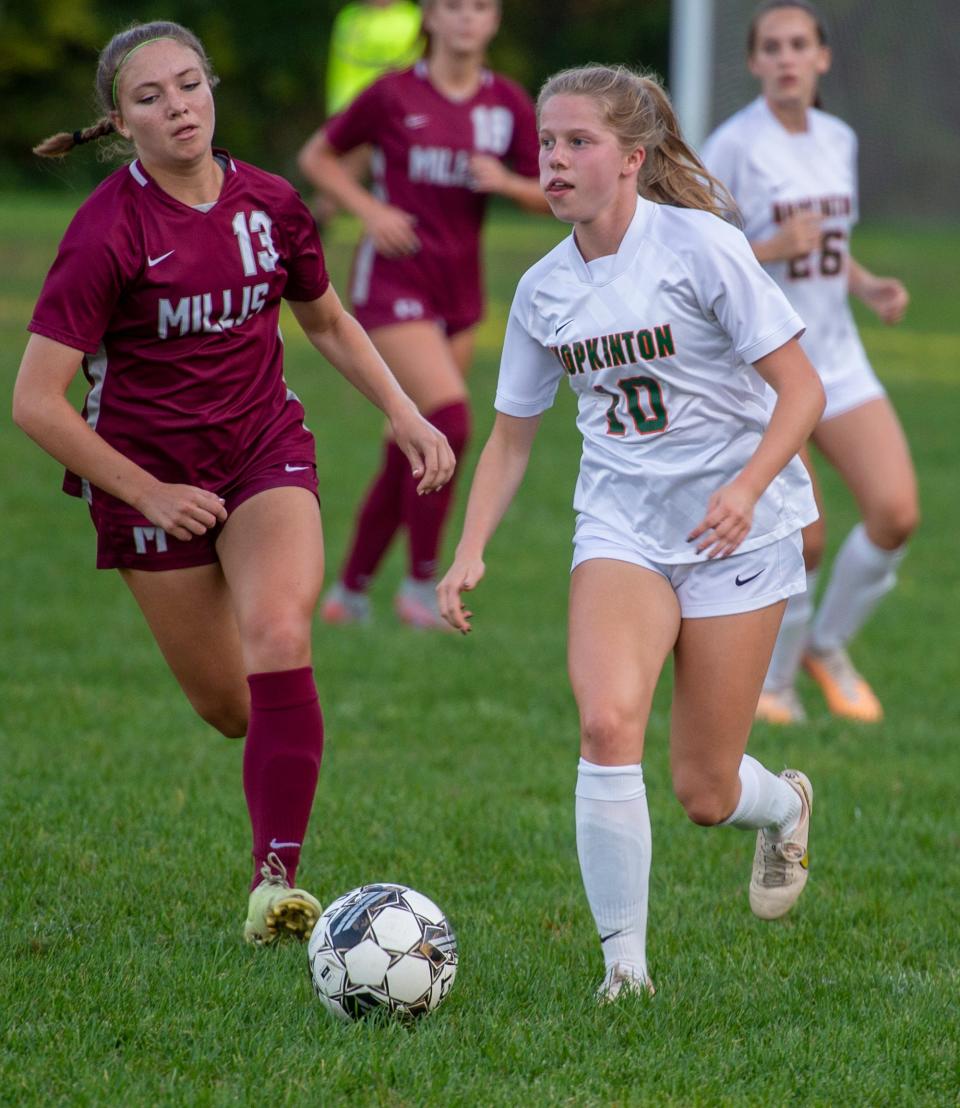 Hopkinton High School junior Madison Recupero brings the ball up the field against Millis sophomore Maddie Steiner, Oct. 3, 2023.