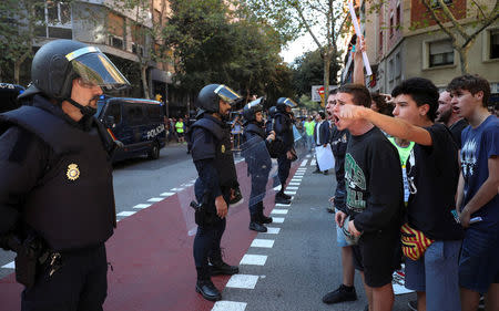 Protestors shout in front of a line of Spanish national police who surrounded the leftist Popular Unity Candidacy (CUP) party headquarters in Barcelona, Spain, September 20, 2017. REUTERS/Albert Gea