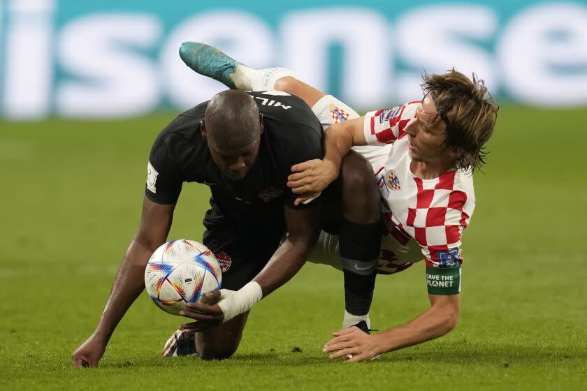 Croatia's Luka Modric fights for the ball with Canada's Kamal Miller during the World Cup group F soccer match between Croatia and Canada, at the Khalifa International Stadium in Doha, Qatar, Sunday, Nov. 27, 2022. (AP Photo/Darko Vojinovic)