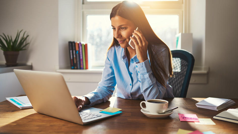 woman working at home and talking on phone