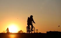 FILE PHOTO: People on bikes enjoy the sunset at the Tempelhofer Feld in Berlin