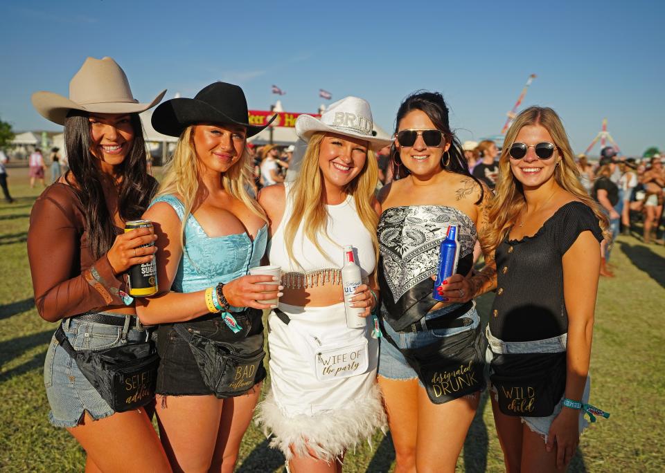 Bride Tara Cardiff and her bridesmaids are all smiles at Country Thunder Music Festival near Florence on April 14, 2023.