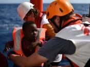 Rescuers take care of a child during an operation in the Mediterranean on the Aquarius, a ship used by Doctors without Borders to reach stranded migrants and refugees